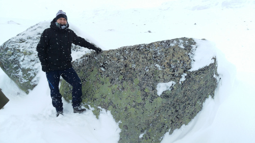 Simon står ved ein stein ute på ein isbre.